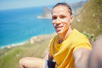 Buy stock photo Shot of a young man taking a selfie while breaking from his hike