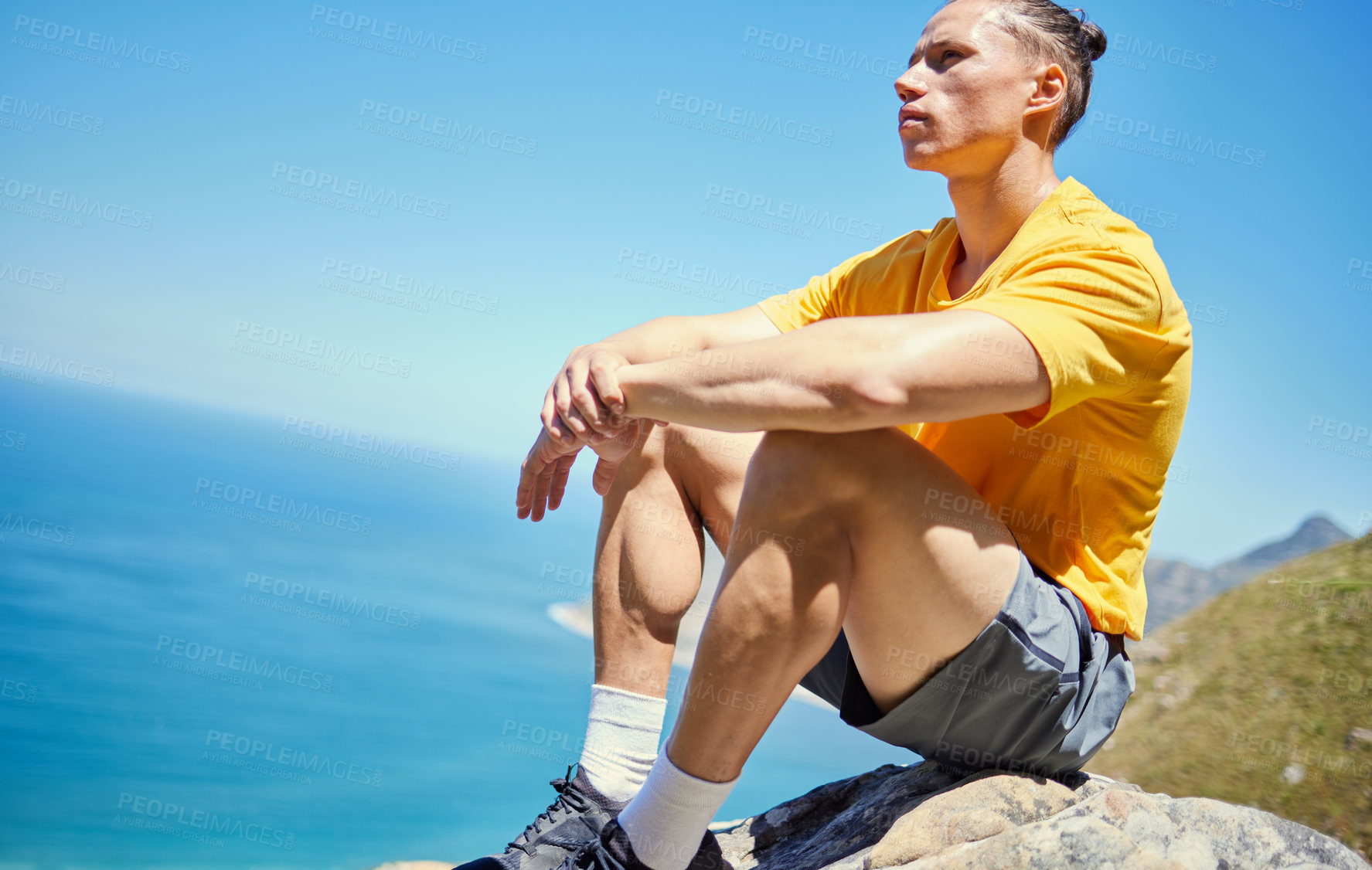 Buy stock photo Man, hiking and rest on mountain by sea, ideas and vision with reflection with blue sky in summer. Person, relax and memory with peace on rocks by ocean, thinking and nature for trekking adventure