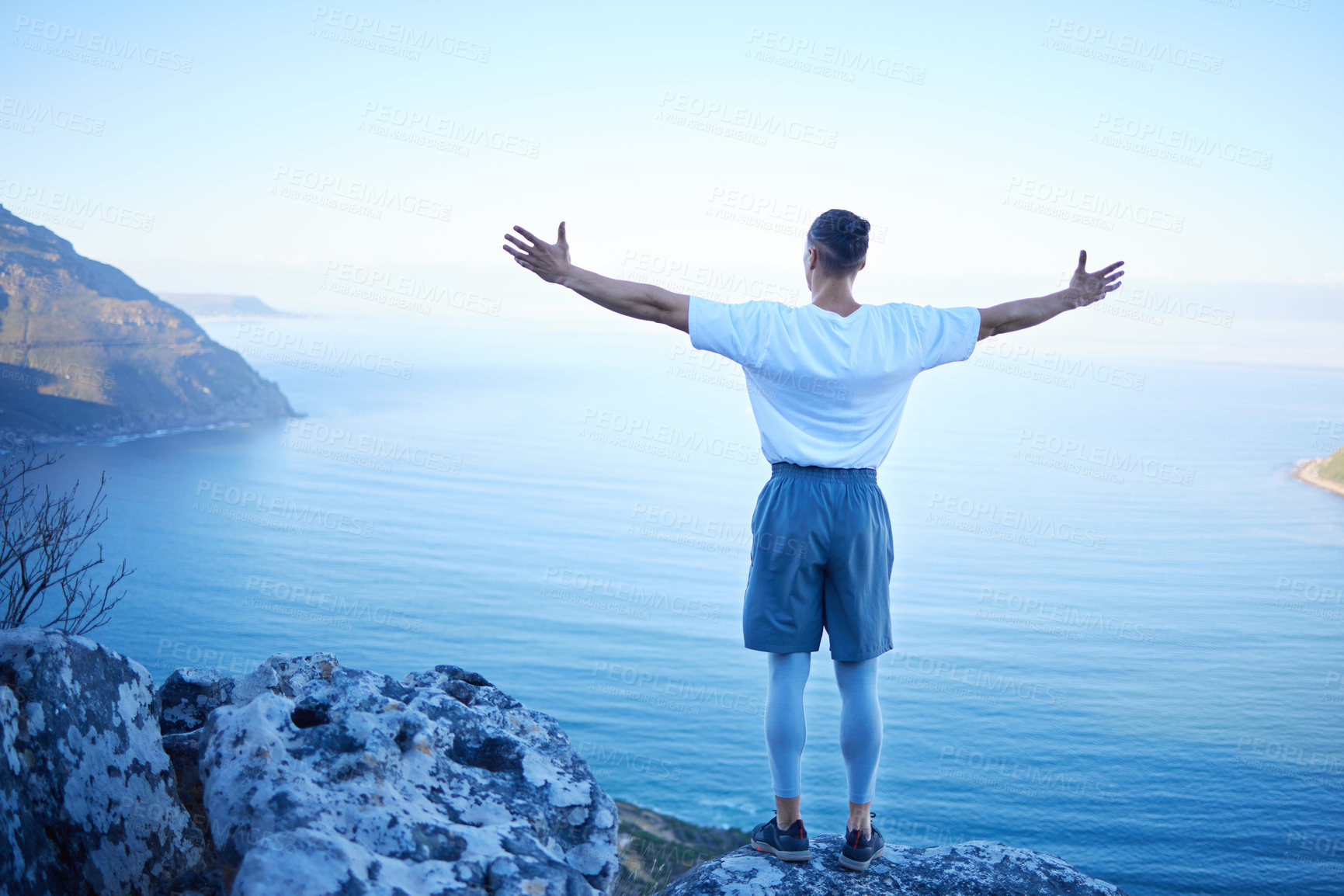 Buy stock photo Man, hiking and back with freedom, arms and stretching for success with view of mountains, sea and nature. Person, achievement and celebration for fitness, training or workout on trekking adventure