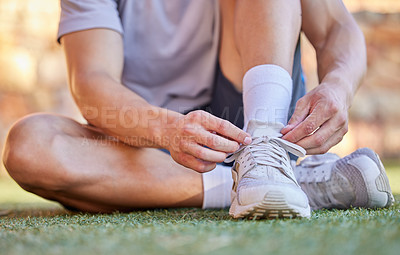 Buy stock photo Shot of an unrecognizable man tying the laces of his running shoes