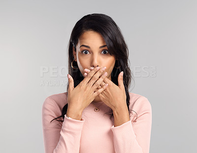 Buy stock photo Shot of a beautiful young woman looking surprised while standing against a grey background