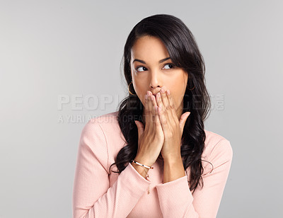 Buy stock photo Shot of a beautiful young woman looking surprised while standing against a grey background