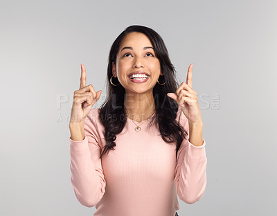 Buy stock photo Shot of a beautiful young woman pointing at copy space