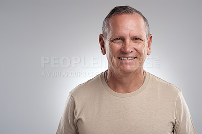 Buy stock photo Shot of a handsome mature man standing alone against a grey background in the studio during the day