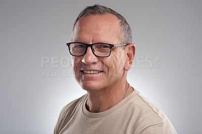 Buy stock photo Shot of a handsome mature man standing alone against a grey background in the studio during the day