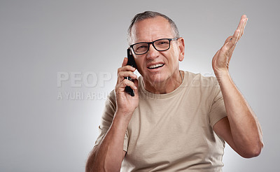 Buy stock photo Shot of a handsome mature man standing against a grey studio background and looking confused while using his cellphone