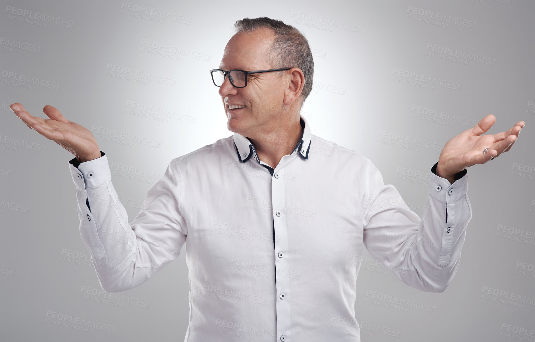 Buy stock photo Shot of a handsome mature businessman standing alone against a grey background in the studio and choosing between two options