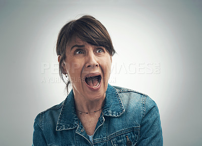 Buy stock photo Studio shot of a senior woman looking scared against a grey background