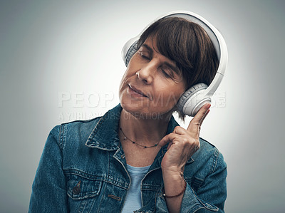 Buy stock photo Studio shot of a senior woman wearing headphones against a grey background