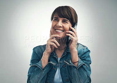 Buy stock photo Studio shot of a senior woman talking on a cellphone against a grey background