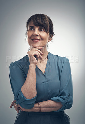 Buy stock photo Studio shot of a senior woman posing with her hand on her chin against a grey background