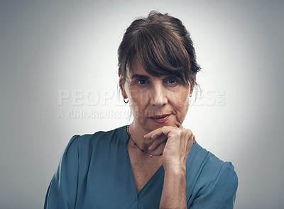 Buy stock photo Studio portrait of a senior woman posing with her hand on her chin against a grey background
