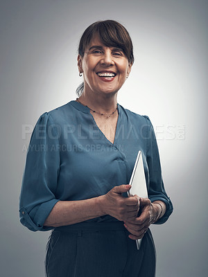 Buy stock photo Studio portrait of a senior woman holding a digital tablet against a grey background