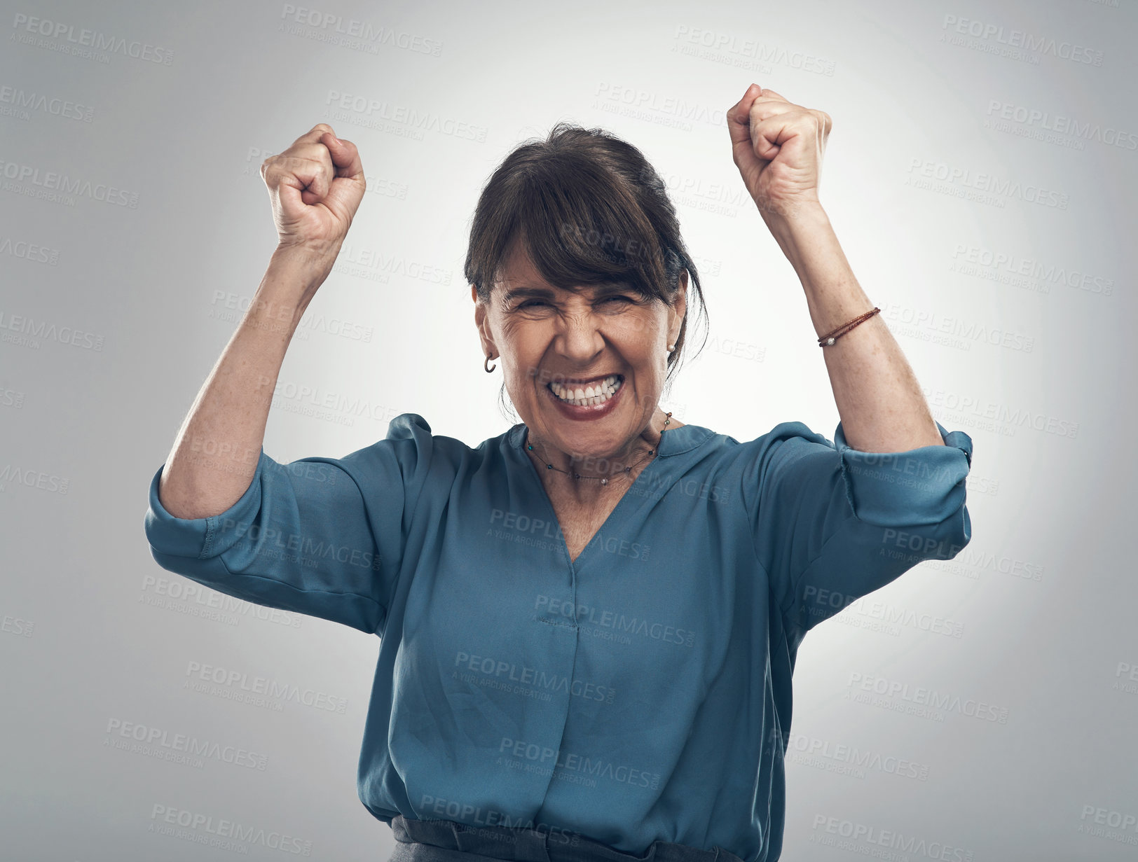 Buy stock photo Studio portrait of a senior woman cheering against a grey background
