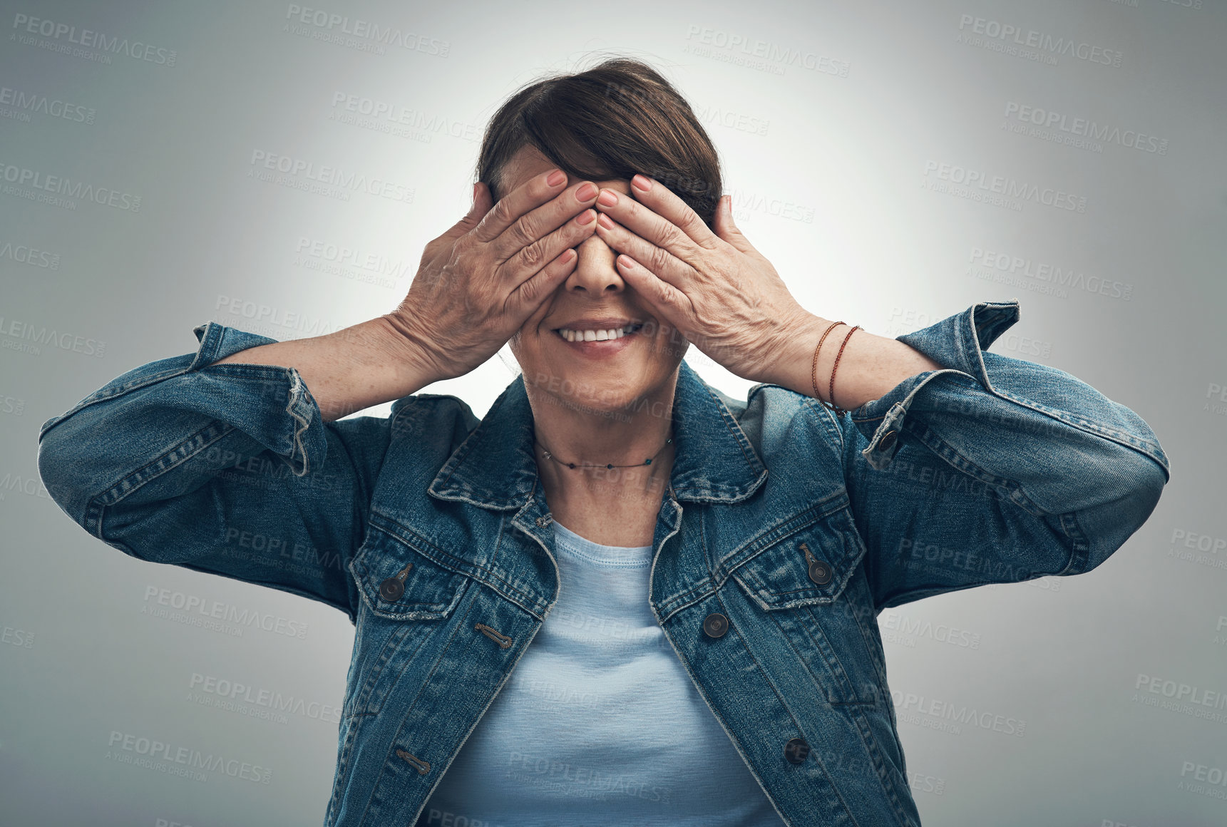 Buy stock photo Studio shot of a senior woman covering her eyes against a grey background