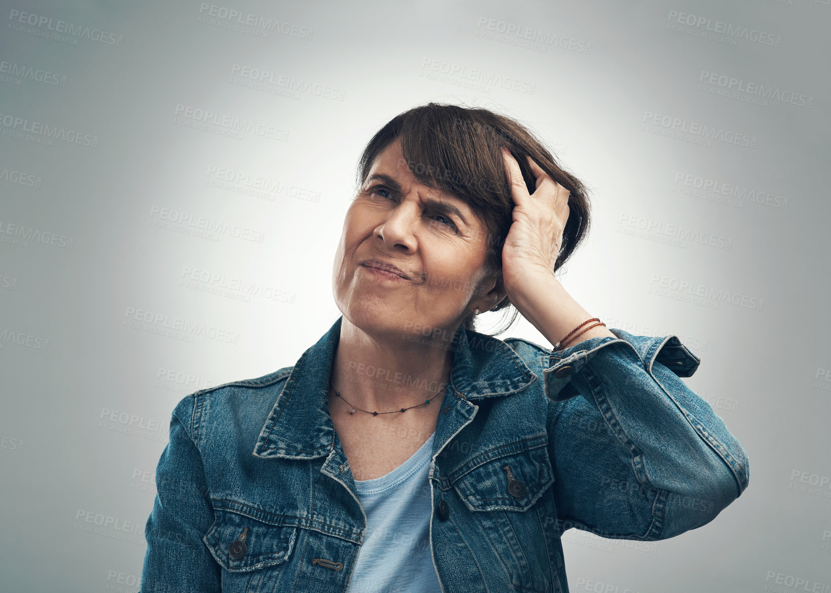 Buy stock photo Studio shot of a senior woman scratching her head in confusion against a grey background