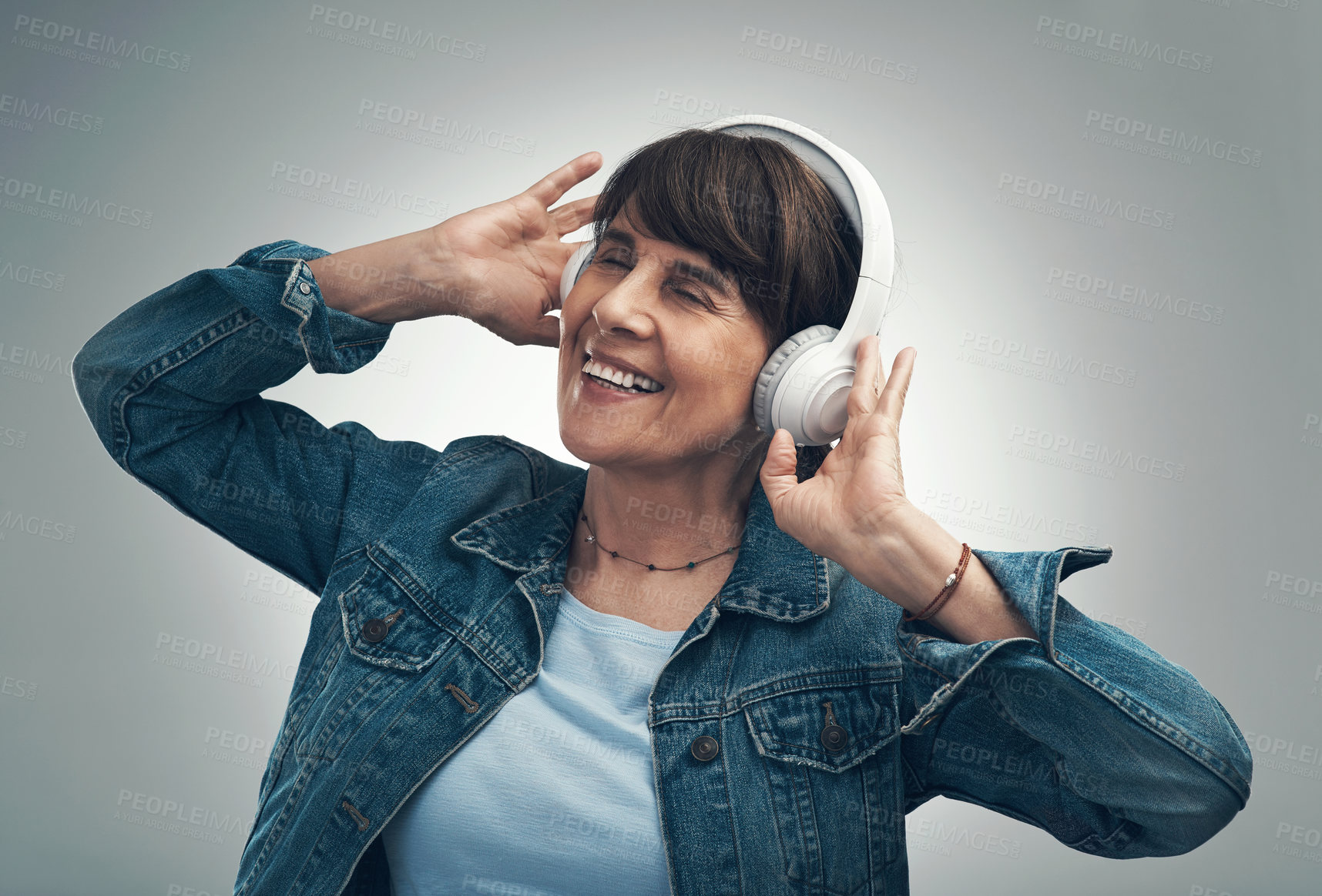 Buy stock photo Studio shot of a senior woman wearing headphones against a grey background