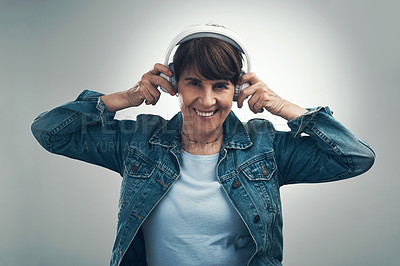 Buy stock photo Studio portrait of a senior woman wearing headphones against a grey background