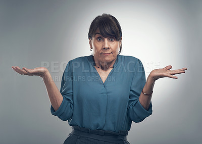 Buy stock photo Studio portrait of a senior woman shrugging against a grey background