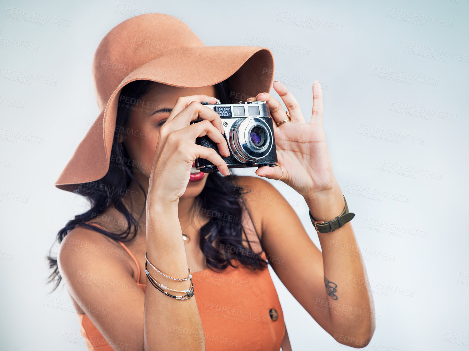 Buy stock photo Studio shot of a beautiful young woman holding a camera while standing against a white background