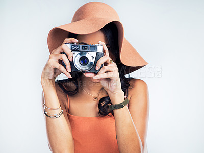 Buy stock photo Studio shot of a beautiful young woman holding a camera while standing against a white background