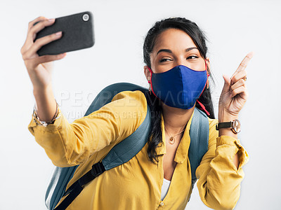 Buy stock photo Shot of a young woman taking a selfie while wearing a mask against a white background