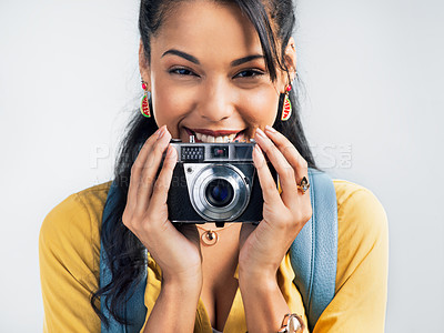 Buy stock photo Studio shot of a beautiful young woman holding a camera while standing against a white background
