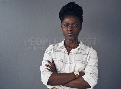 Buy stock photo Shot of an attractive young businesswoman standing alone against a grey background in the office with her arms folded