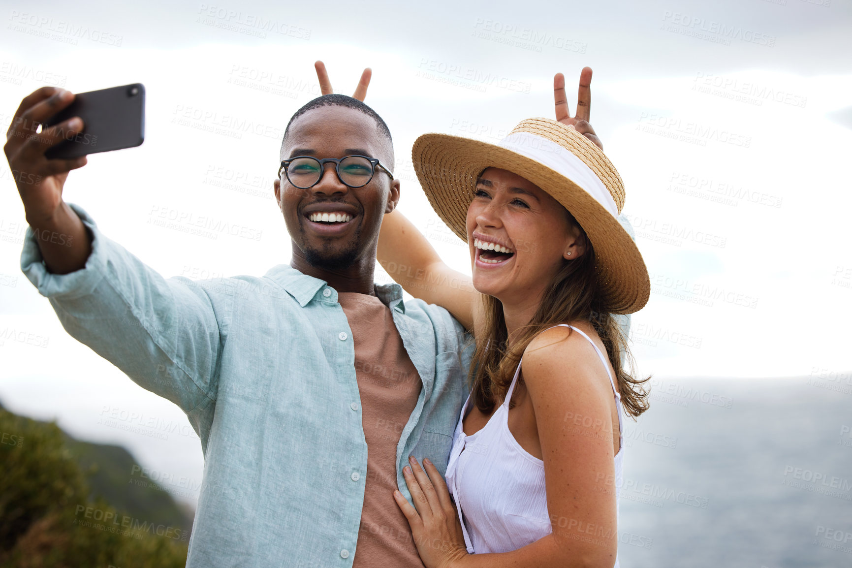 Buy stock photo Road trip, interracial couple and funny for selfie in nature, travel and countryside or vacation in Brazil. Comic, people and happy using phone for picture or holiday, journey and bunny ears together