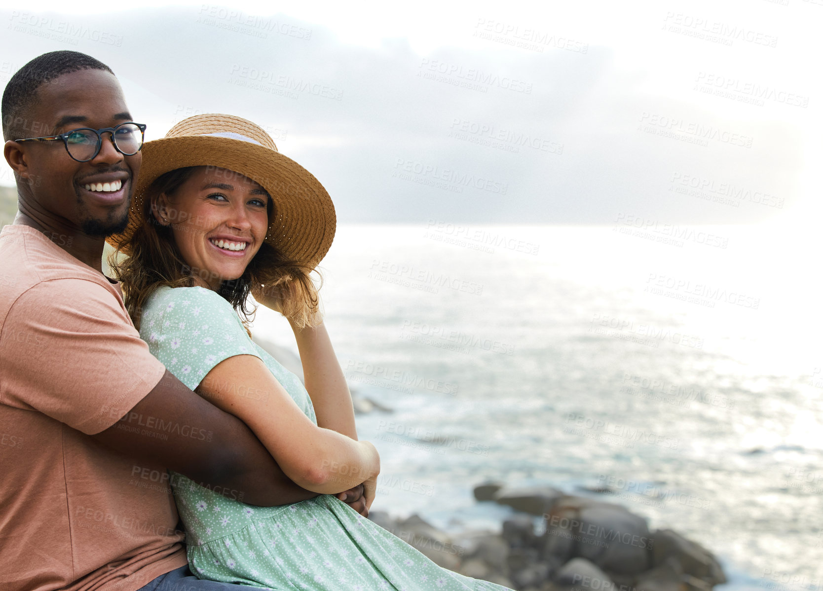 Buy stock photo Interracial couple, portrait and happy for hug by beach, nature and ocean or sea for vacation in Brazil. Adventure, people and smile on road trip outdoor for holiday, journey and relax together