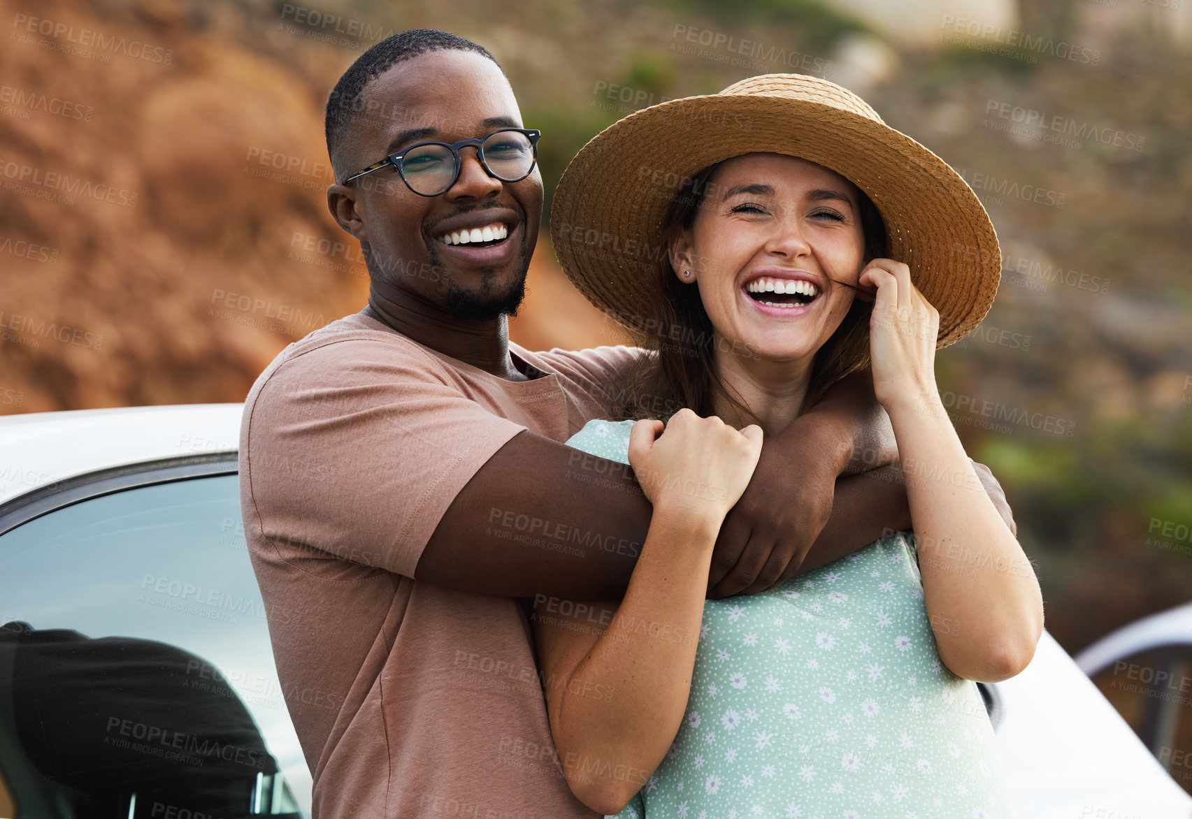 Buy stock photo Interracial couple, portrait and road trip for hug by nature, environment and countryside for vacation. Adventure, people and smile or funny outdoor for holiday, journey or relax by car together