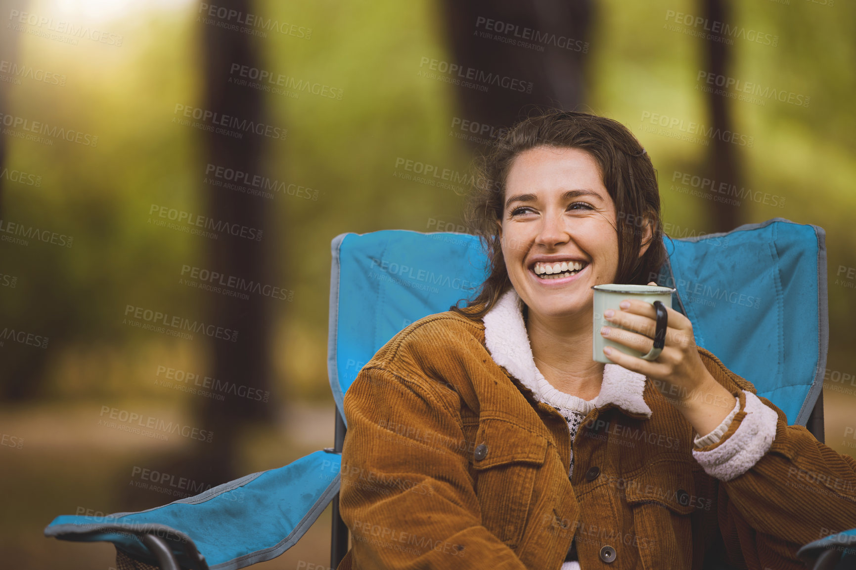 Buy stock photo Shot of a woman drinking coffee while sitting on a camping chair outside