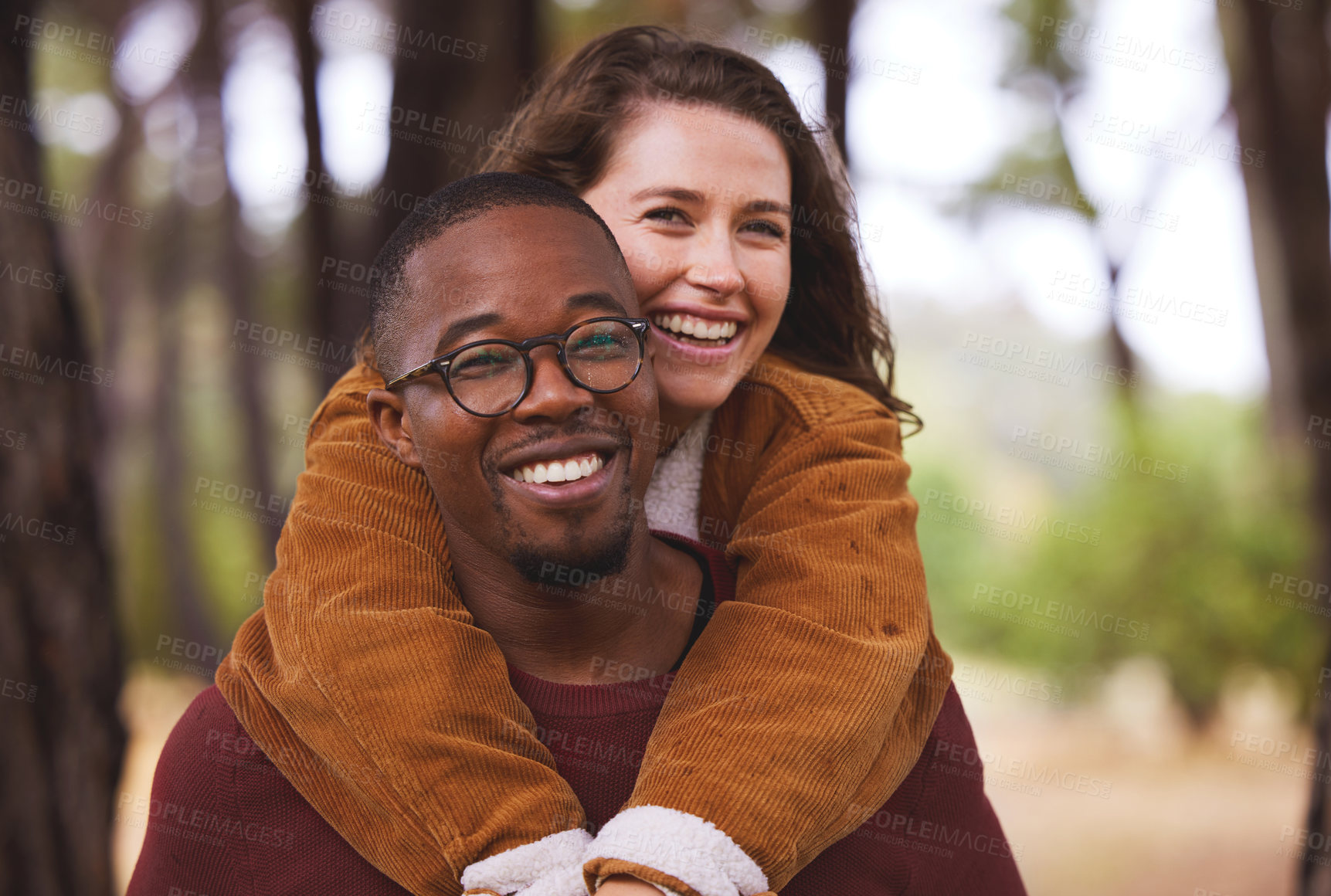 Buy stock photo Love, portrait and couple piggyback in outdoor for camping in wilderness on anniversary date in Norway, countryside. Interracial people, travel and happy on vacation in forest for peace and adventure