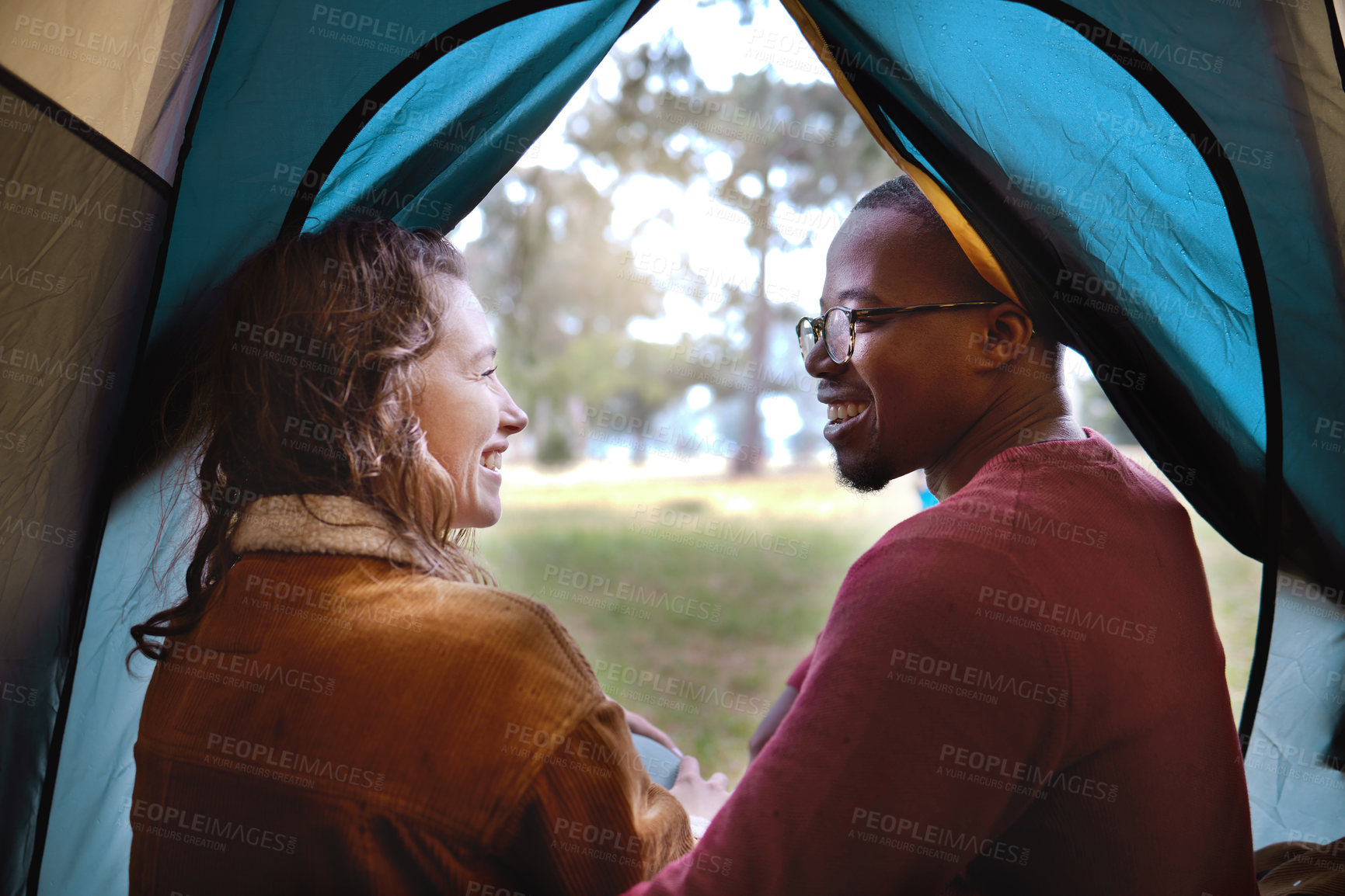 Buy stock photo Shot of a young couple camping in the wilderness