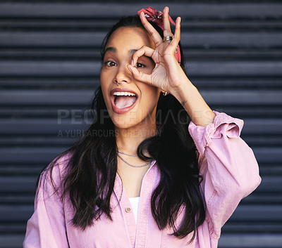 Buy stock photo Excited, woman and eye with okay hand sign, urban fashion and smile at garage door. Happiness, gen z girl and streetwear with perfect gesture, confident and face with emoji on dark background