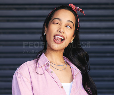 Buy stock photo Cropped shot of an attractive young woman winking playfully while posing against a grey background