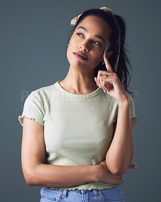 Buy stock photo Studio shot of a young woman looking thoughtful against a grey background