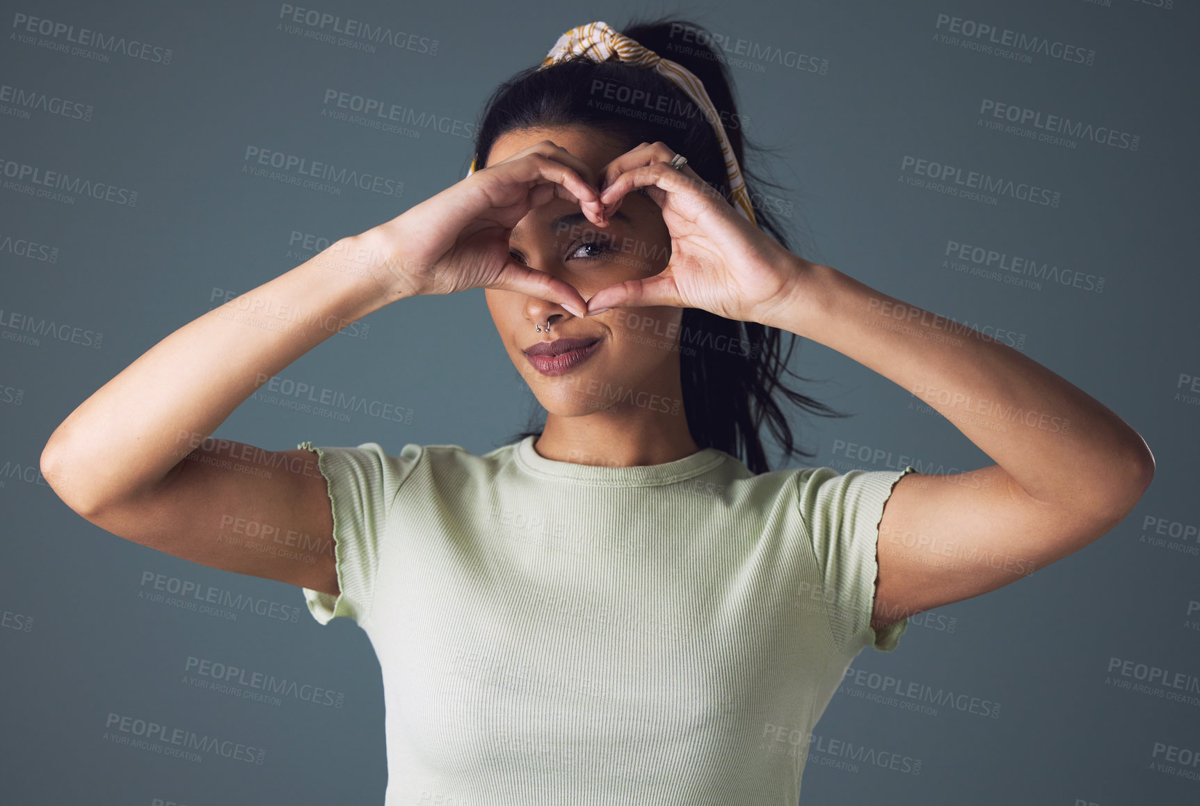 Buy stock photo Girl, fashion and eye with heart hand in studio on grey background in casual, style and gen z. Portrait, smile and cool with emoji or love sign and symbol for appreciation, support and positive