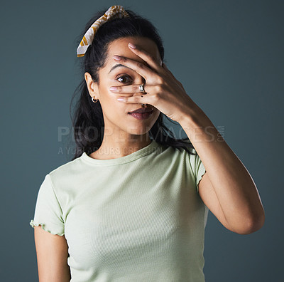 Buy stock photo Woman, studio and hide with hand, peeking or spying portrait isolated on grey background. Model, peeping or watching for secret, suspect and curious with covered eye for shy or suspicious reaction