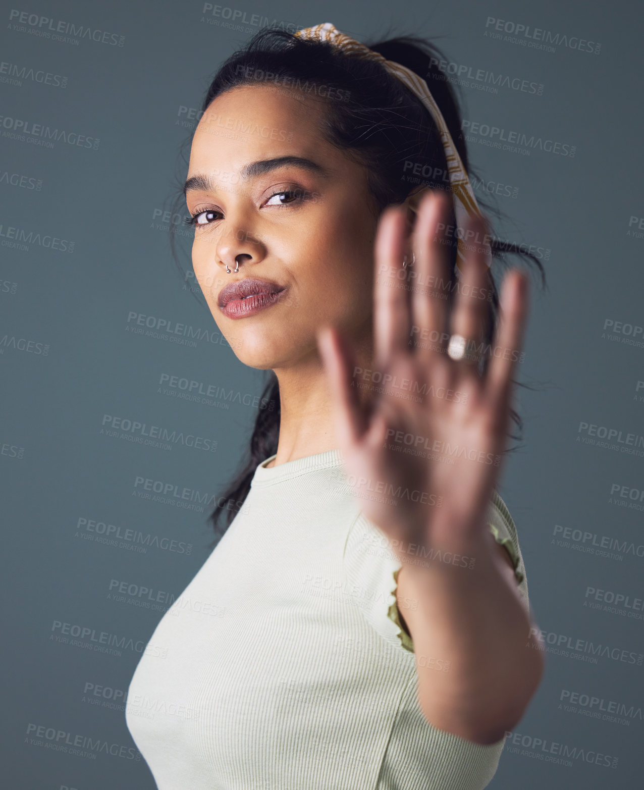 Buy stock photo Shot of a woman holding up her hand while standing against a grey background