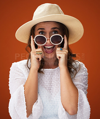 Buy stock photo Portrait, excited and woman with sunglasses for fashion surprise in studio isolated on a red background. Face, wow and happy person with hat in casual clothes, cool and ready for vacation in Germany