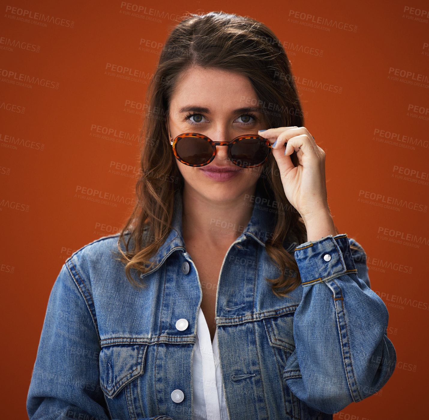 Buy stock photo Studio shot of a stylish young woman posing against a brown background