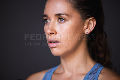 Buy stock photo Shot of a sporty young woman standing against a grey background