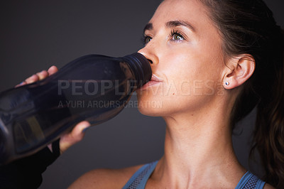 Buy stock photo Woman, exercise and drinking water in studio for workout hydration or healthy sports, grey background or training. Female person, bottle and beverage for cardio fitness or liquid, thirsty or break
