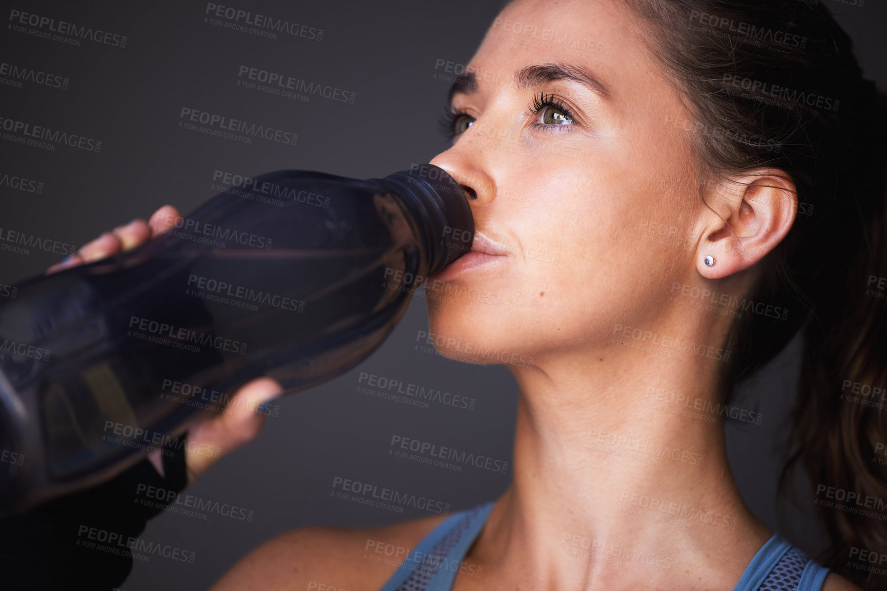 Buy stock photo Woman, exercise and drinking water in studio for workout hydration or healthy sports, grey background or training. Female person, bottle and beverage for cardio fitness or liquid, thirsty or break