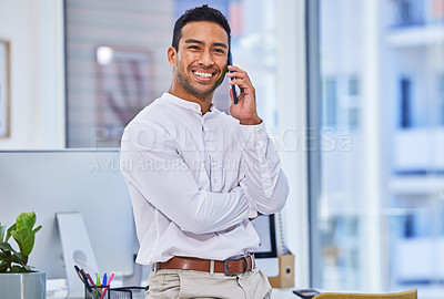 Buy stock photo Shot of a businessman talking on his cellphone while standing in an office