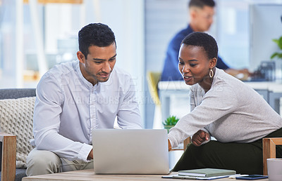 Buy stock photo Shot of two businesspeople discussing something on a laptop while sitting together in an office