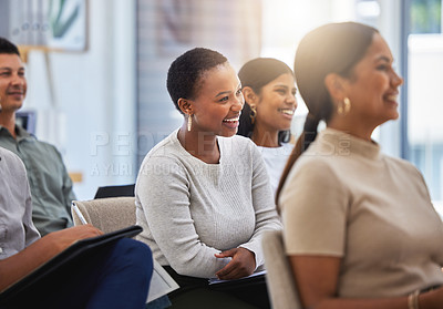 Buy stock photo Shot of a group of employees laughing during a meeting at work in a modern office