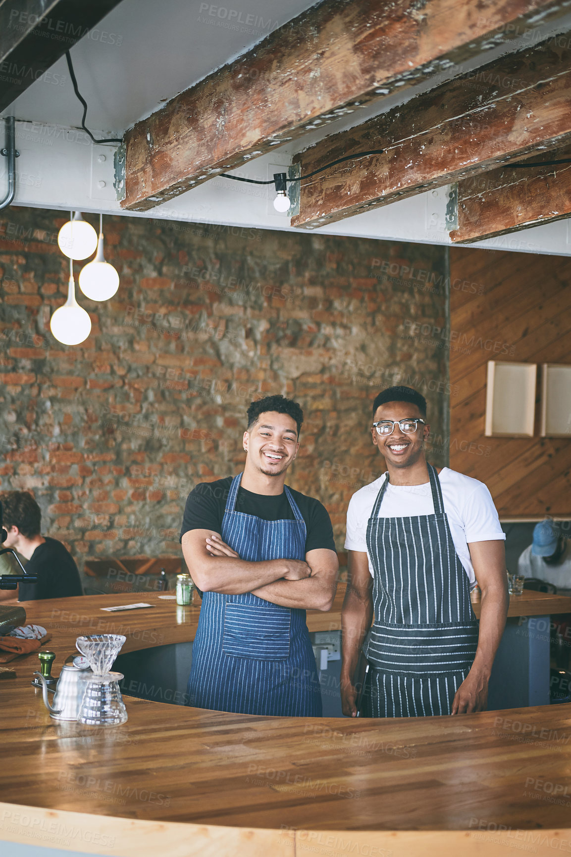 Buy stock photo Shot of two confident young men working in a cafe