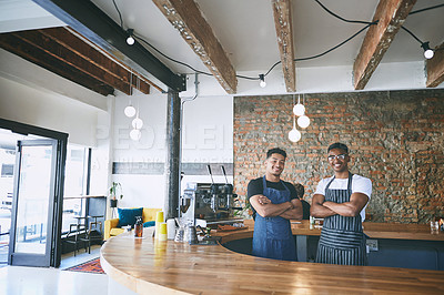 Buy stock photo Shot of two confident young men working in a cafe